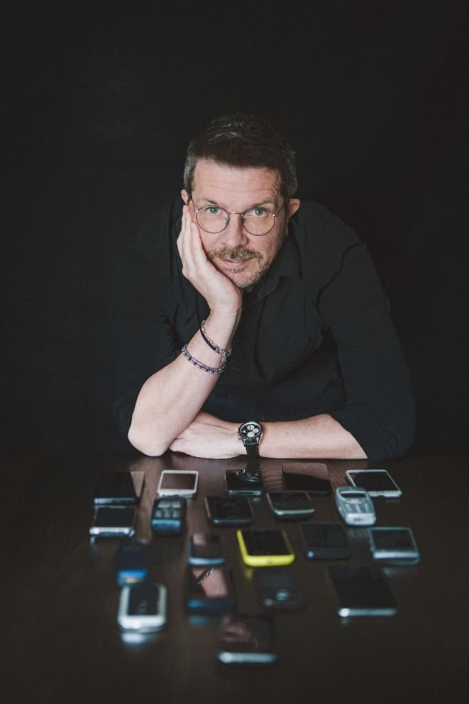Ivo Weevers with a collection of mobile phones on a table